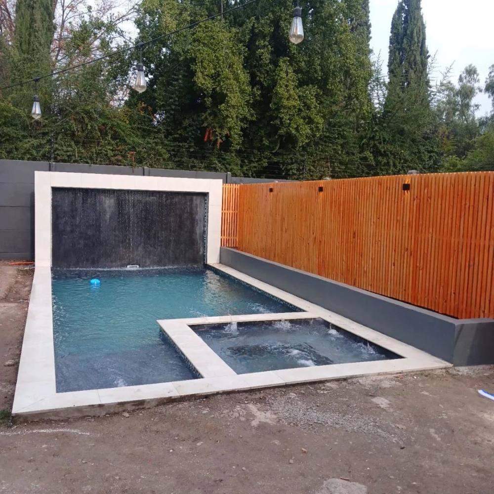 Piscina terminada con cascada y muro de madera